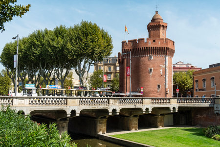 PERPIGNAN, FRANCE - SEPTEMBER 14, 2019: A view of the Magenta bridge above the Basse River in Perpignan, France, and Le Castillet fortress, an iconic landmark in the city, in the backgroundのeditorial素材