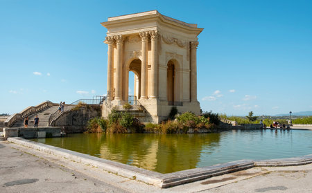 MONTPELLIER, FRANCE - SEPTEMBER 19, 2019: A view of the Promenade du Peyrou garden in Montpellier, France, highlighting the Chateau de eau, its iconic neoclassical water tower, presiding over the pondのeditorial素材