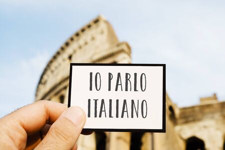 Closeup of the hand of a caucasian man holding sign with the text io parlo italiano, I speak Italian, written in Italianの写真素材