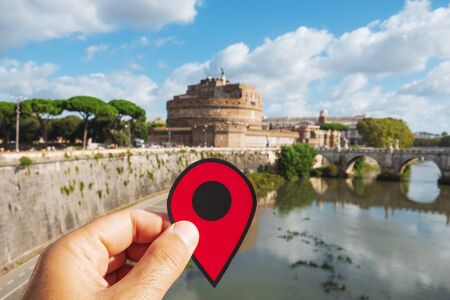 Closeup of the hand of a caucasian man holding a red marker at the famous Castel Sant Angelo or Mausoleum of Hadrian, in Rome, Italyの写真素材
