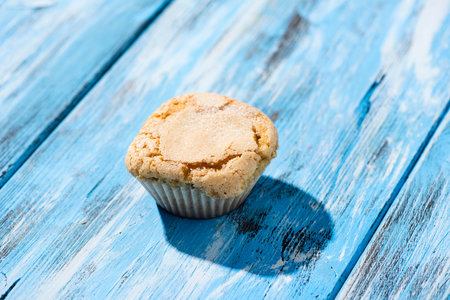 a plain muffin on a rustic blue wooden surface