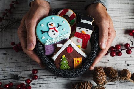 Closeup of a young caucasian man with a pile of christmas cookies in his hands