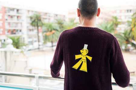 young man outdoors with a paper man in his back as a prank for the dia de los inocentes, the...