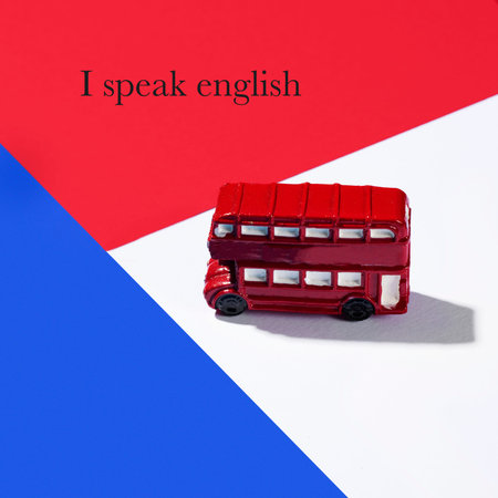a miniature of a typical red double-decker bus on a background with the colors of the flag of the...