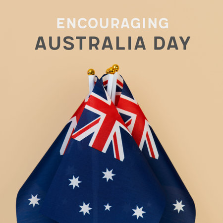 closeup of some australian flags and the text happy encouraging day against a light brown background
