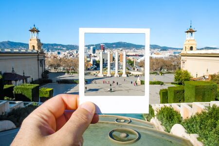 closeup of a man with a white frame in his hand, framing the Four Columns in Montjuic Hill, in Barcelona, Spain, simulating an instant photoの写真素材