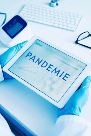 closeup of a doctor man, wearing blue surgical gloves, having a digital tablet in his hands with the...