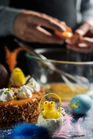 man preparing a typical mona de pascua, a cake eaten in Spain on Easter Monday, decorated with a...