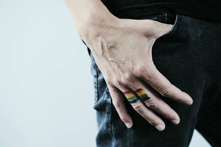Closeup of a rainbow flag in the hand of a young caucasian personの写真素材