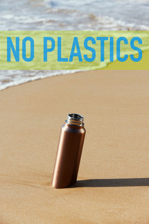 the text no plastics and an aluminum reusable water bottle on the seashore of a lonely beach