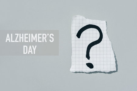a question mark in a piece of paper and the text Alzheimers day on a gray background