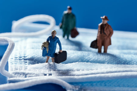 some miniature people on a blue disposable face mask, depicting concepts such as back to work or...