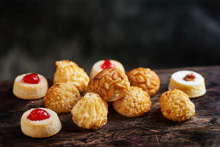 a pile of panellets, typical confection of Catalonia, Spain, eaten traditionally in All Saints Day, on a wooden tableの写真素材