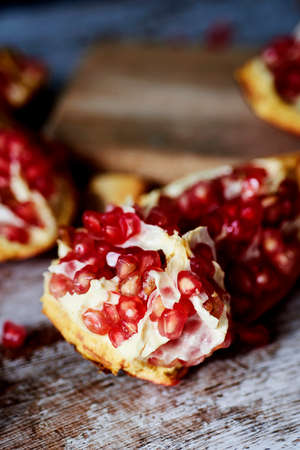 some pieces of a pomegranate fruit on a rustic wooden tableの写真素材