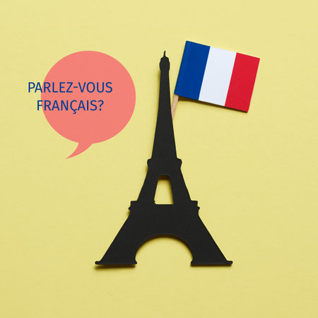 the eiffel tower, cutout on a black paperboard, the french flag and the question do you speak french written in french, on a yellow backgroundの写真素材