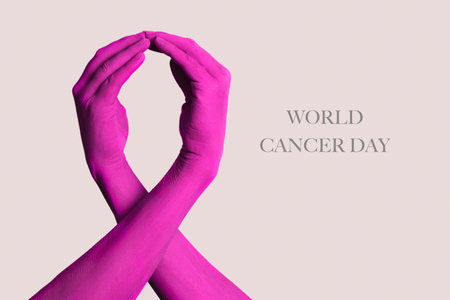 closeup of the arms of two people painted pink forming a pink awareness ribbon, for the breast cancer awareness, and the text world cancer day on a pale pink backgroundの写真素材