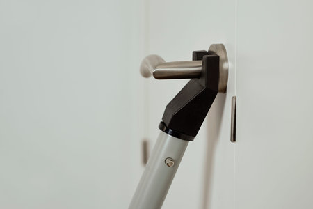 closeup of a door blocker security bar in use in a white door