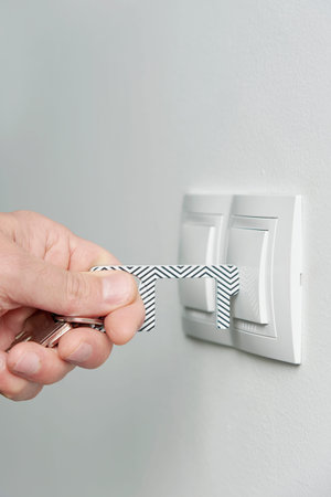 A young caucasian man pushes a button with a non-contact button pusher device