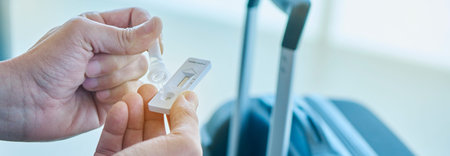 closeup of a young caucasian man placing his own sample into the antigen diagnostic test device in...
