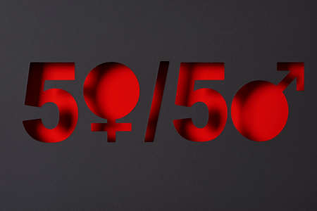 the expression 50-50, where the zero is depicted with a female gender symbol and a male gender symbol, cut out in a black paper, as a depiction of the gender equality conceptの写真素材