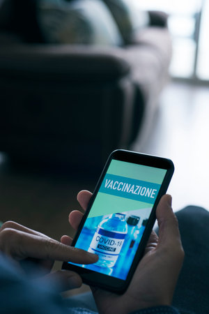 closeup of a young caucasian man, sitting at his living room, watching at his smartphone, that reads...