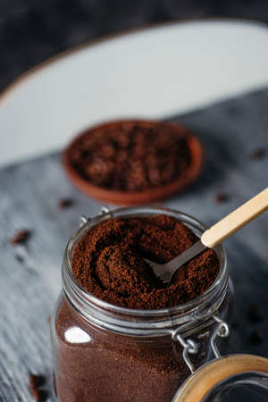 closeup of a hermetic glass jar full of ground coffee on a gray rustic wooden tableの写真素材