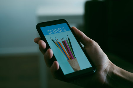 closeup of a young caucasian man is searching schools online with his smartphone, with a simulated...