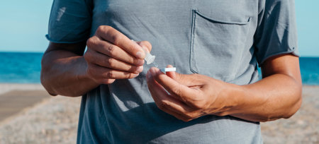 a young caucasian man, in summer casual wear, places his own sample into the  antigen diagnostic...