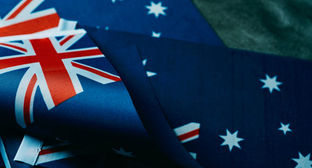 closeup of some australian flags on a dark gray background