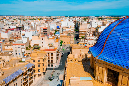 an aerial view of the old town of Elche, in Spain, highlighting the blue dome of the Basilica of Santa Maria church, dedicated to the Virgin Maryの写真素材