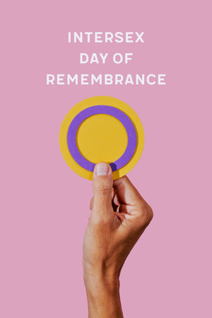 closeup of a person holding a circular intersex flag in their hand, and the text intersex day of...