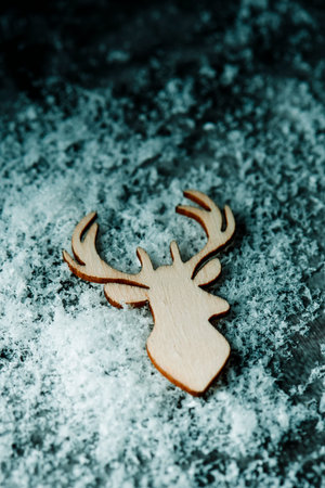 high angle view of the silhouette of a reindeer head cut out on wooden on a pile of snowの写真素材