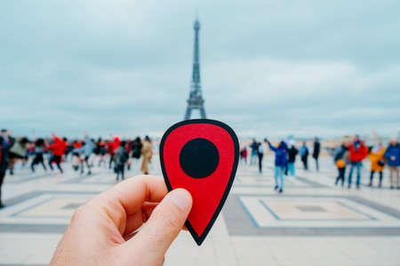 the hand of a young caucasian man holding a red marker pointing the Eiffel Tower in Paris, Franceの写真素材