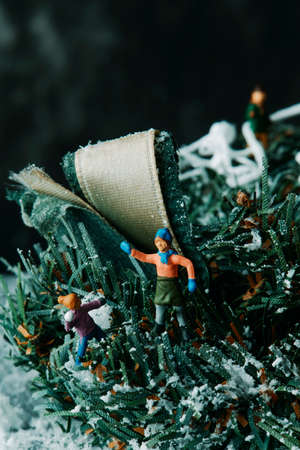 closeup of some miniature people playing with some fake snowの写真素材