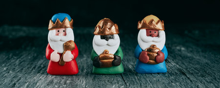 the three wise men, melchior, caspar and balthazar, on a gray rustic surface, in a panoramic format...