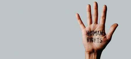 the hand of a man with the text human rights written in his palm, on an off-white background, in a panoramic format to use as web banner or headerの写真素材