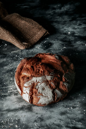 a round kamut wheat bread loaf on a mottled dark gray fabric surface
