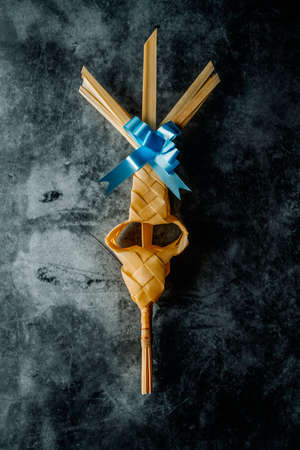 high angle view of a traditional Spanish braided palm leaf, typically blessed on Palm Sunday, on a black mottled surfaceの写真素材