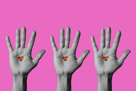 three raised hands in black and white with a heart-shaped rainbow flag painted in his palm on a...