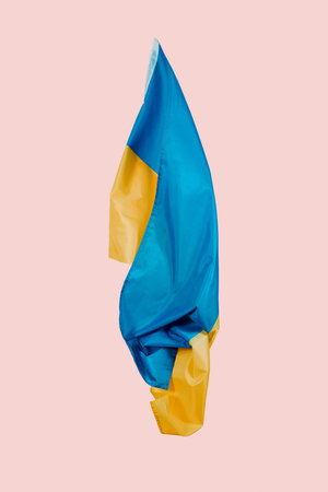 closeup of the ukrainian flag flying in the air on a pink background