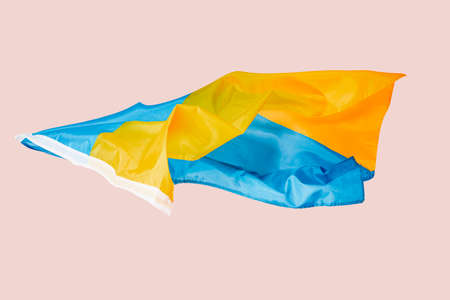 the ukrainian flag flying in the air in front of a pink backgroundの写真素材