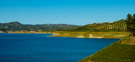 a view over the Iznajar reservoir, in Andalusia, Spain, in a spring day, in a panoramic format to use as web banner or headerの写真素材