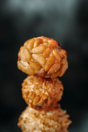 closeup of a stack of assorted panellets, a confection typical of All Saints Day in Catalonia, Spain: with pine nut bits, with almond bits, and a coconut panellet at the baseの写真素材