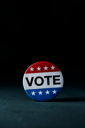 closeup of a badge for the United States election, with the text vote written in it, on a dark gray...