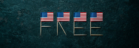 some american flags forming the word free with their poles on a dark gray textured background, in a panoramic format to use as web banner or headerの写真素材
