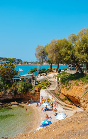 Vouliagmeni, Greece - September 1, 2022: Some people is relaxing  in a small cave in Vouliagmeni,...