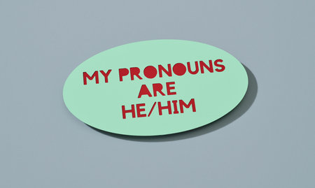 a pale green sign with the text my pronouns are he, him on a pale blue backgroundの写真素材