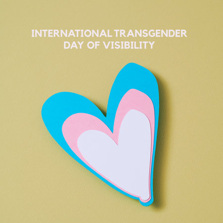 the text international transgender day of visibility and a heart with the colors of the transgender flag on a pale yellow backgroundの写真素材