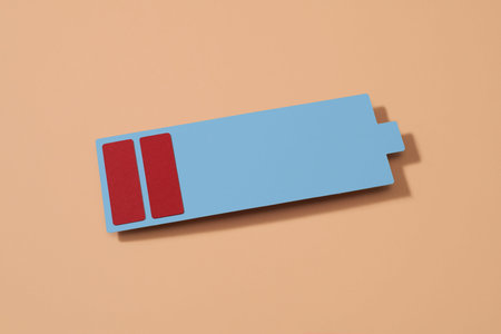 a cardboard depiction of a low battery on a pale pink background