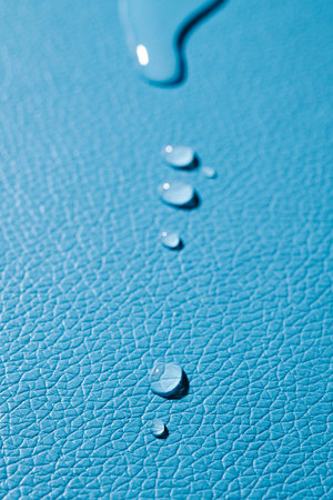 closeup of some drops of water on a blue leather surfaceの写真素材